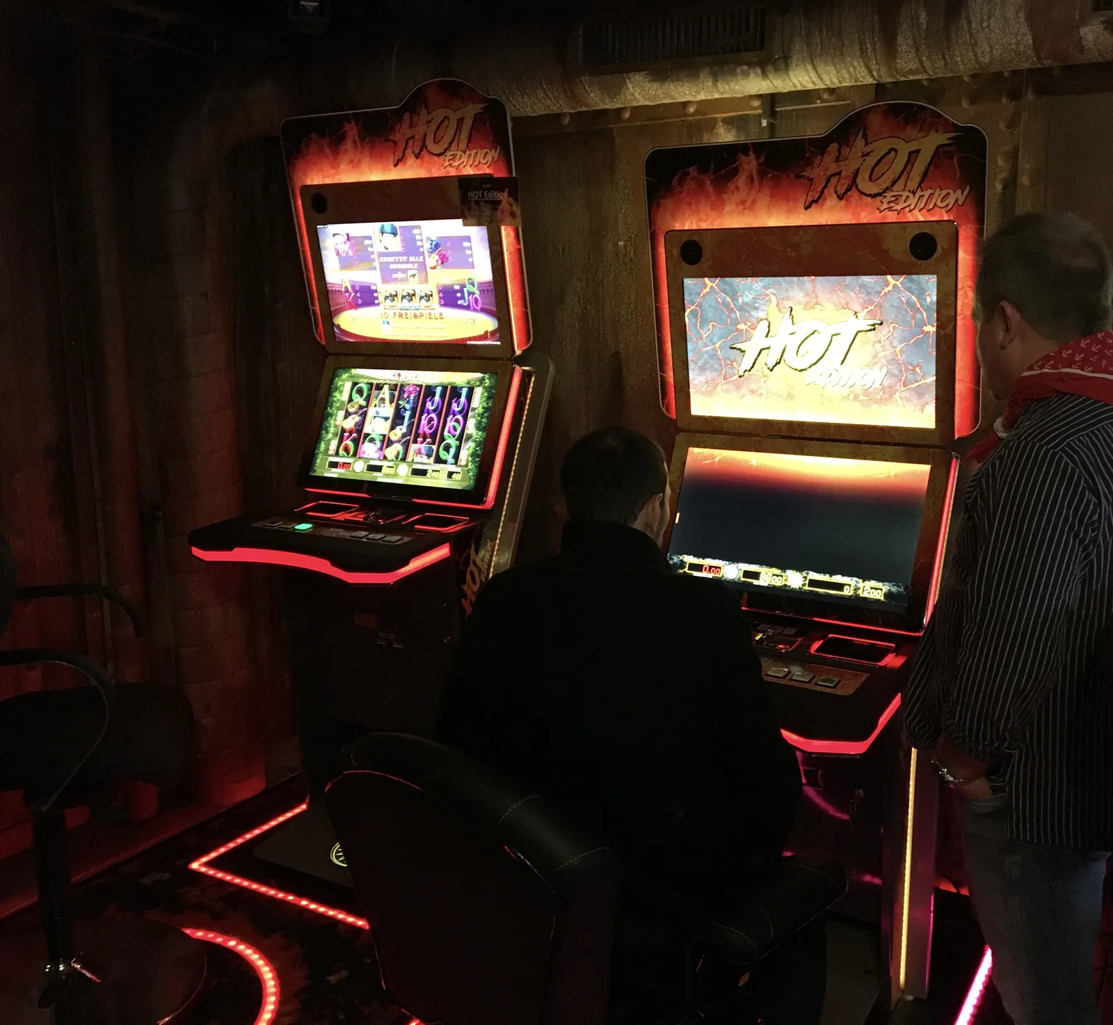 Zwei Hot-Edition-Spielautomaten in atmosphärischer Bar-Umgebung